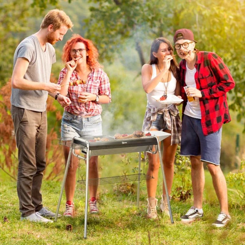 Barbacoa de carbón Outsunny 107 cm con parrilla y plancha desmontable: en uso durante una barbacoa