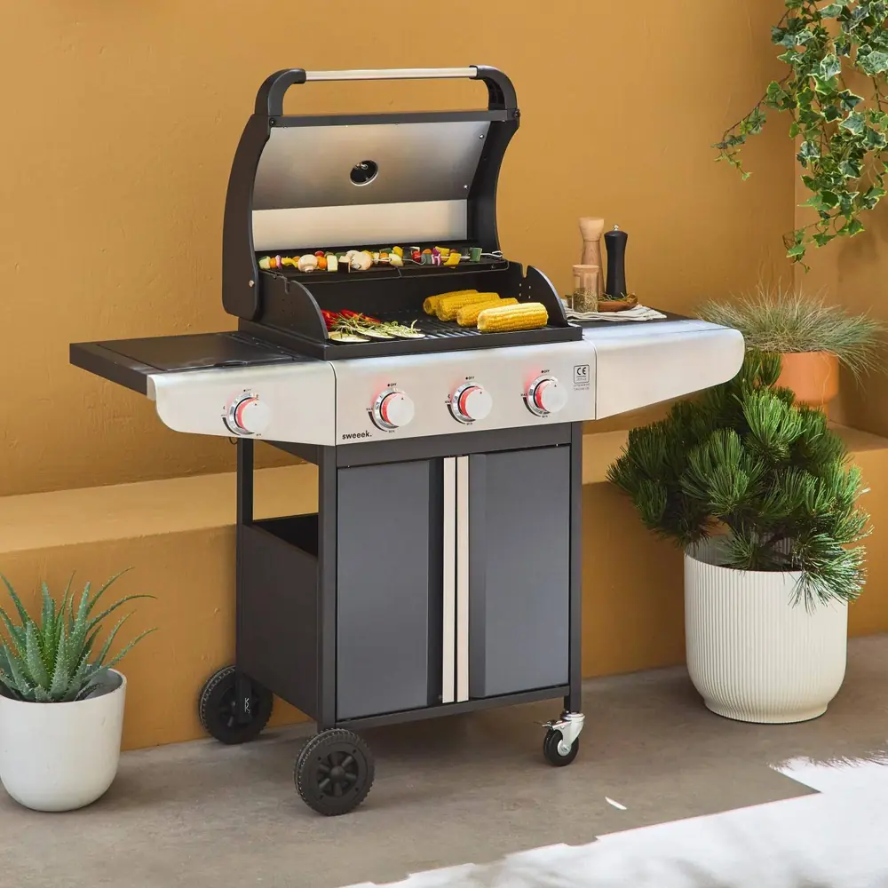 Barbacoa de gas Bazin 3+1 quemadores 12,8 kW con armario y ruedas: con la comida hecha en la parrilla y la rejilla superior