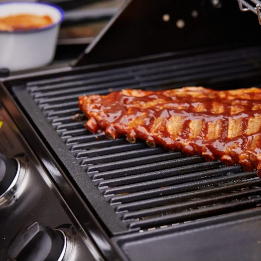 Barbacoa de gas BeefEater Discovery 1200E 4 quemadores con carro: con la comida hecha en la parrilla y la rejilla superior