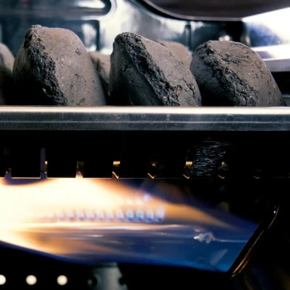 Barbacoa híbrida de gas y carbón Grillstream Gourmet 4 quemadores inox: las briquetas de carbón encendiéndose sobre la llama del quemador de gas