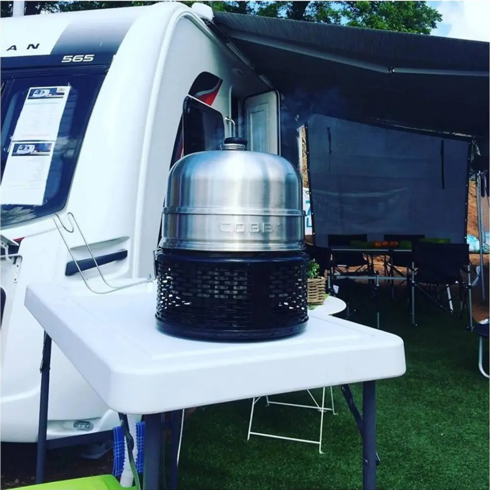 Barbacoa portátil de carbón COBB Pro negra que no quema por fuera: usándola de camping, junto a la tienda