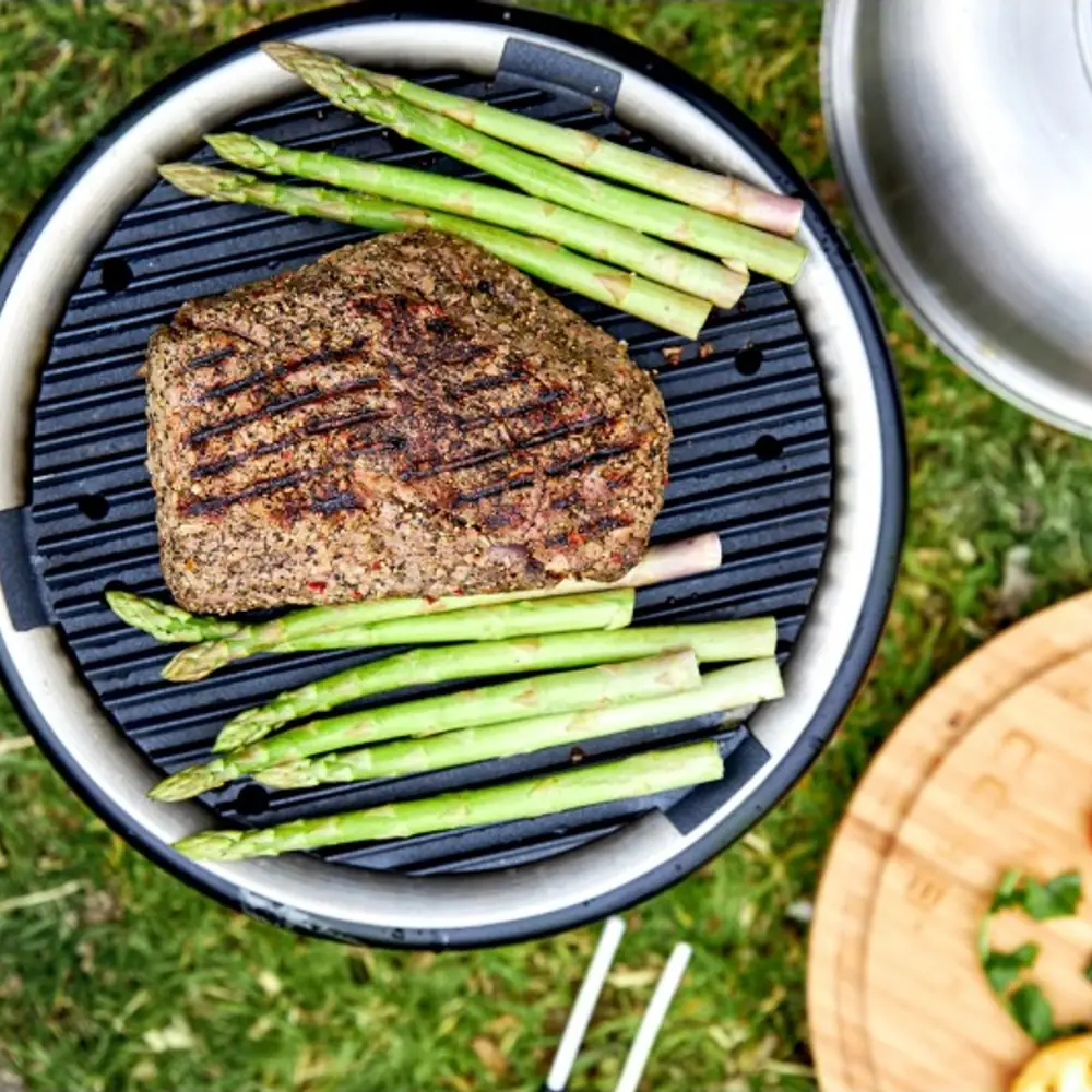 Barbacoa portátil de carbón COBB Pro negra que no quema por fuera: con la comida hecha en la parrilla y la rejilla superior