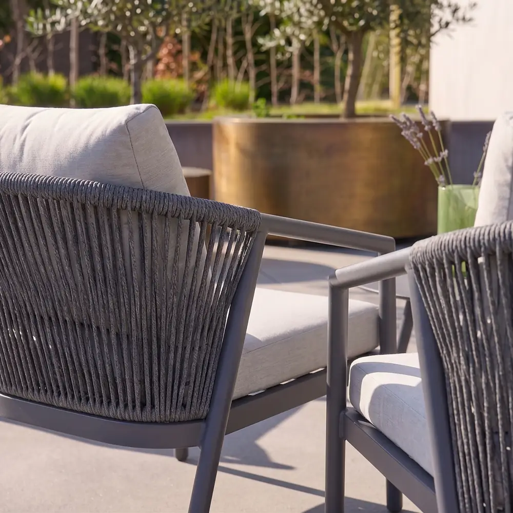 Conjunto de jardín de aluminio y cuerdas gris para 4 personas con mesa redonda: detalle del respaldo de cuerdas trenzadas y de los cojines gruesos