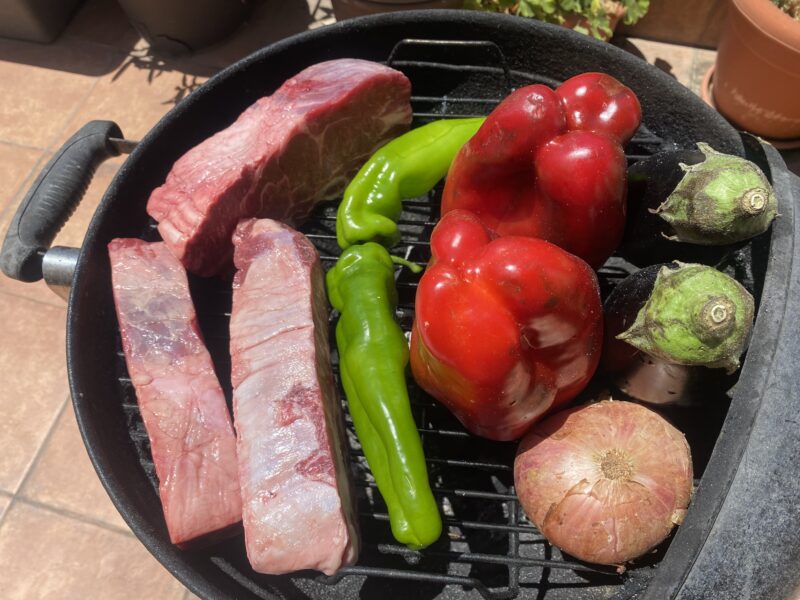 Barbacoa de carbón con la tapa abierta cocinando en indirecto