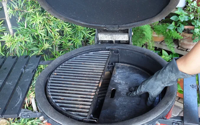Parrilla de hierro fundido de barras gruesas y plancha de media luna dentro de un kamado