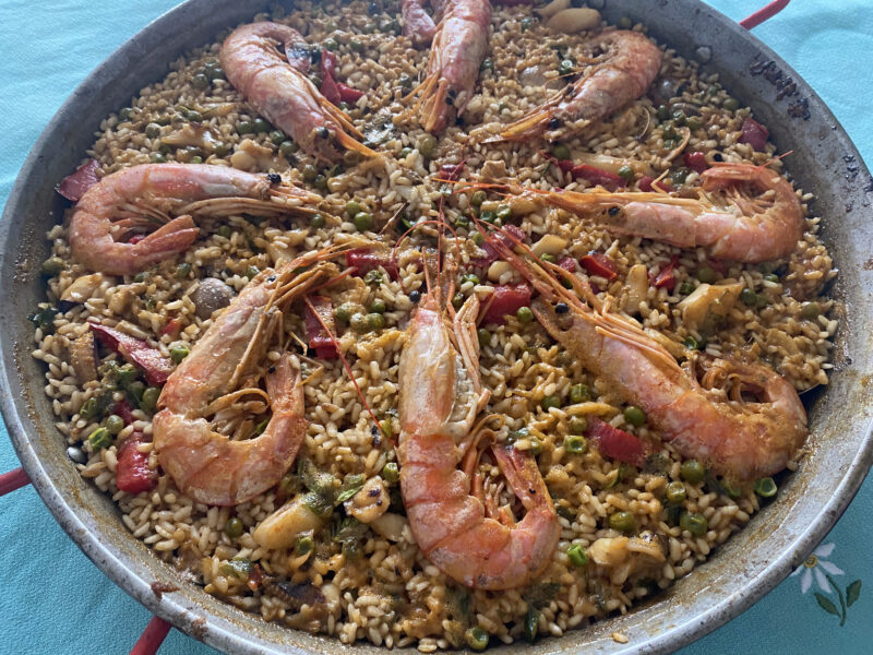 Paellera con gambas colocadas en corona sobre el arroz