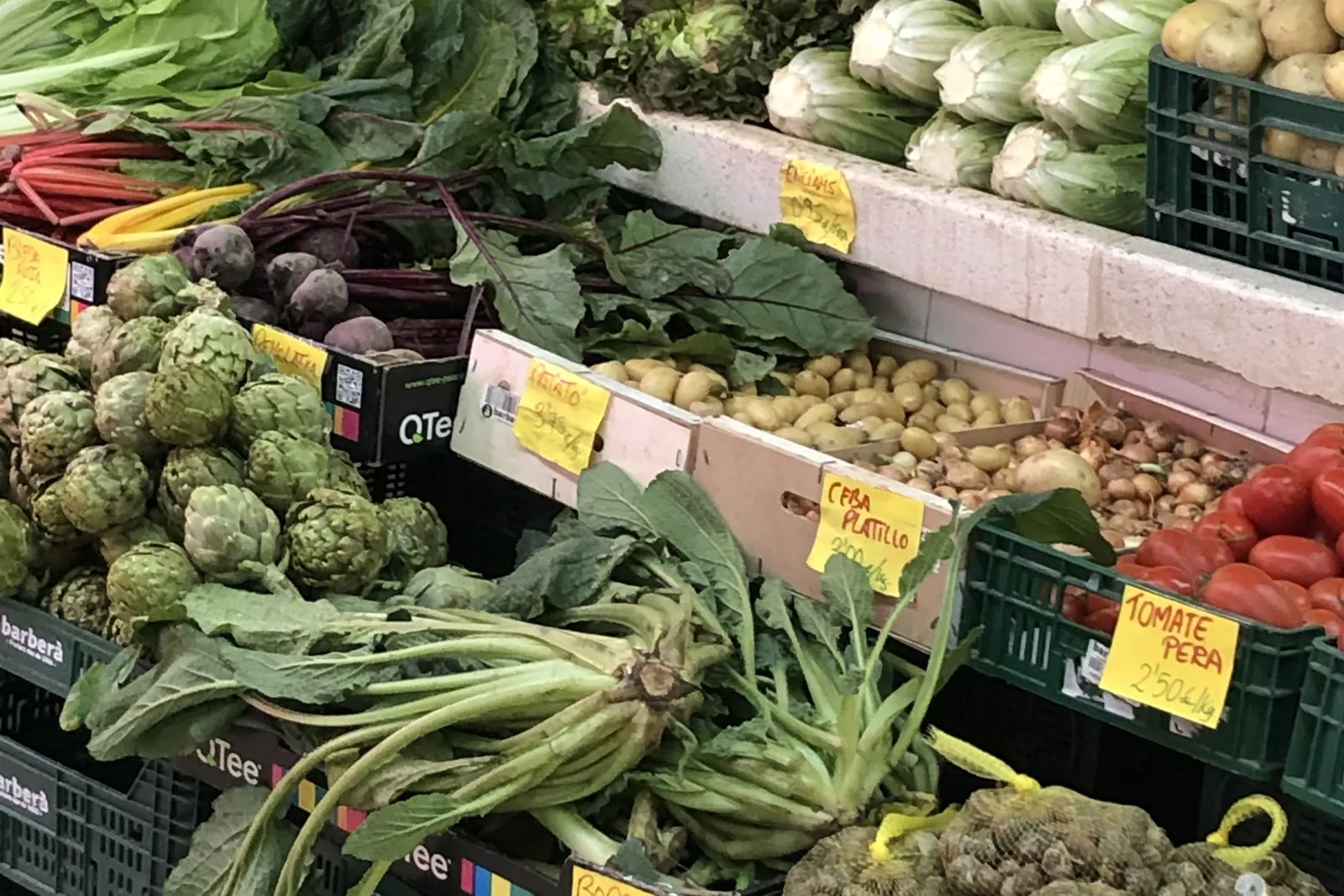 Puesto de mercado con verdura fresca: alcachofas, acelgas, coles y lechugas