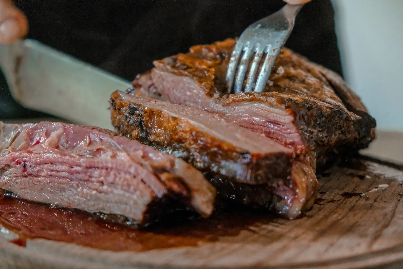 Picanha cortada en lonchas gruesas, rosada y jugosa por dentro, con un tenedor sujetando la carne