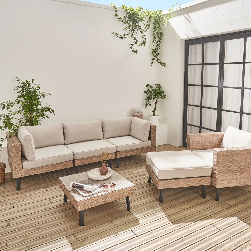 Conjunto de muebles de jardín de resina trenzada con sofá, sillón, puf y mesa de centro en una terraza