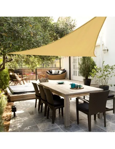 Toldo vela triangular de color crema dando sombra a una mesa de comedor exterior en una terraza
